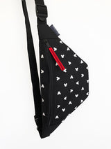 black mickey mouse sling bag with white mickey mouse heads and with red zipper pull made from cordura fabric