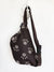 dark brown fanny pack with light brown animal paws printed on the outside, zipper pocket on the front and adjustable strap with optional buckle type